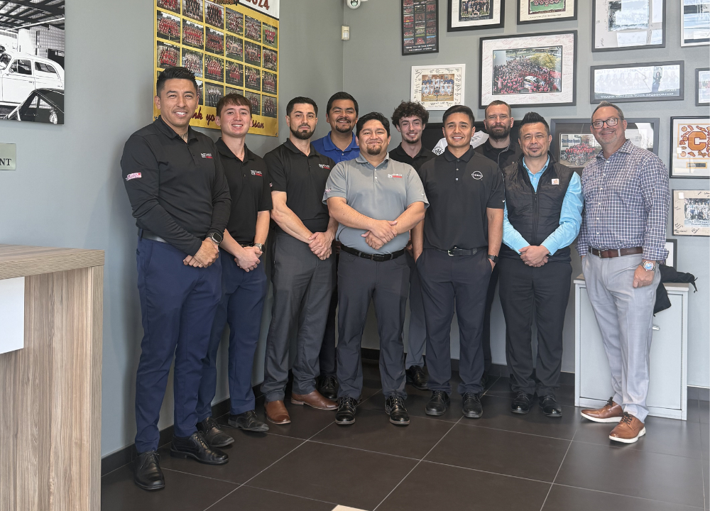 The Chico Nissan sales team posing together inside the dealership showroom in Chico, CA — Best of Chico 2024 Best Car Dealership banner visible in background
